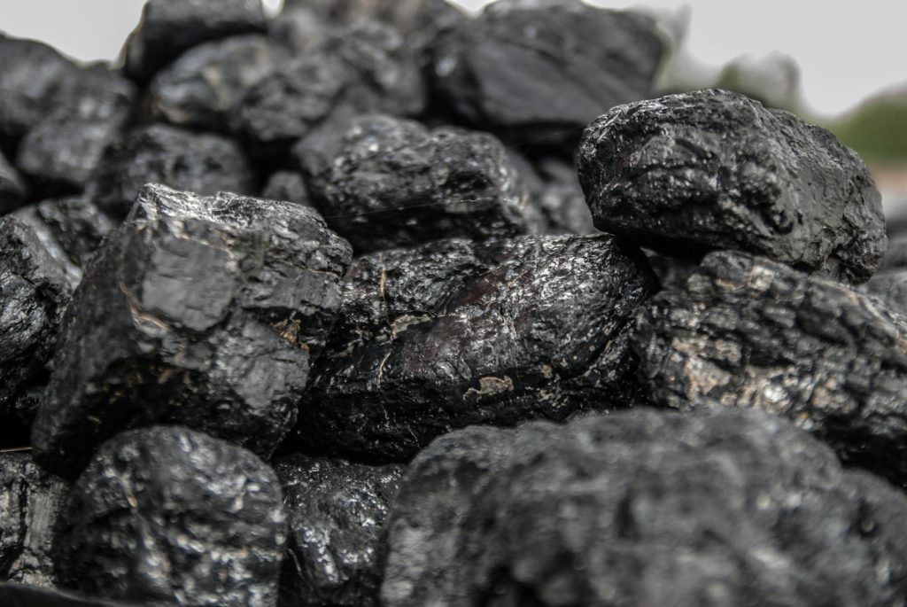 Detailed image of dark, textured coal pieces in a close-up view, highlighting their rugged surface.