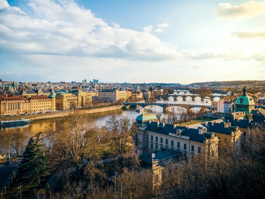 A beautiful aerial view of Prague showcasing its iconic bridges and river at sunset.